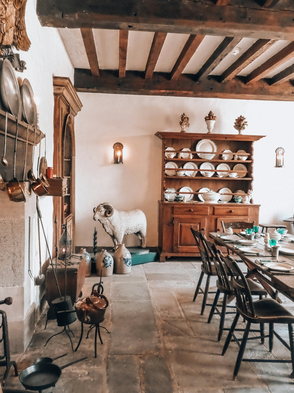 Rustic dining room with antique furniture, exposed beams, and kitchenware