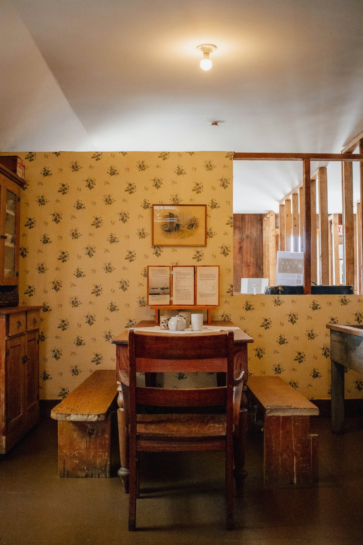 A vintage dining room with patterned wallpaper and wooden furniture